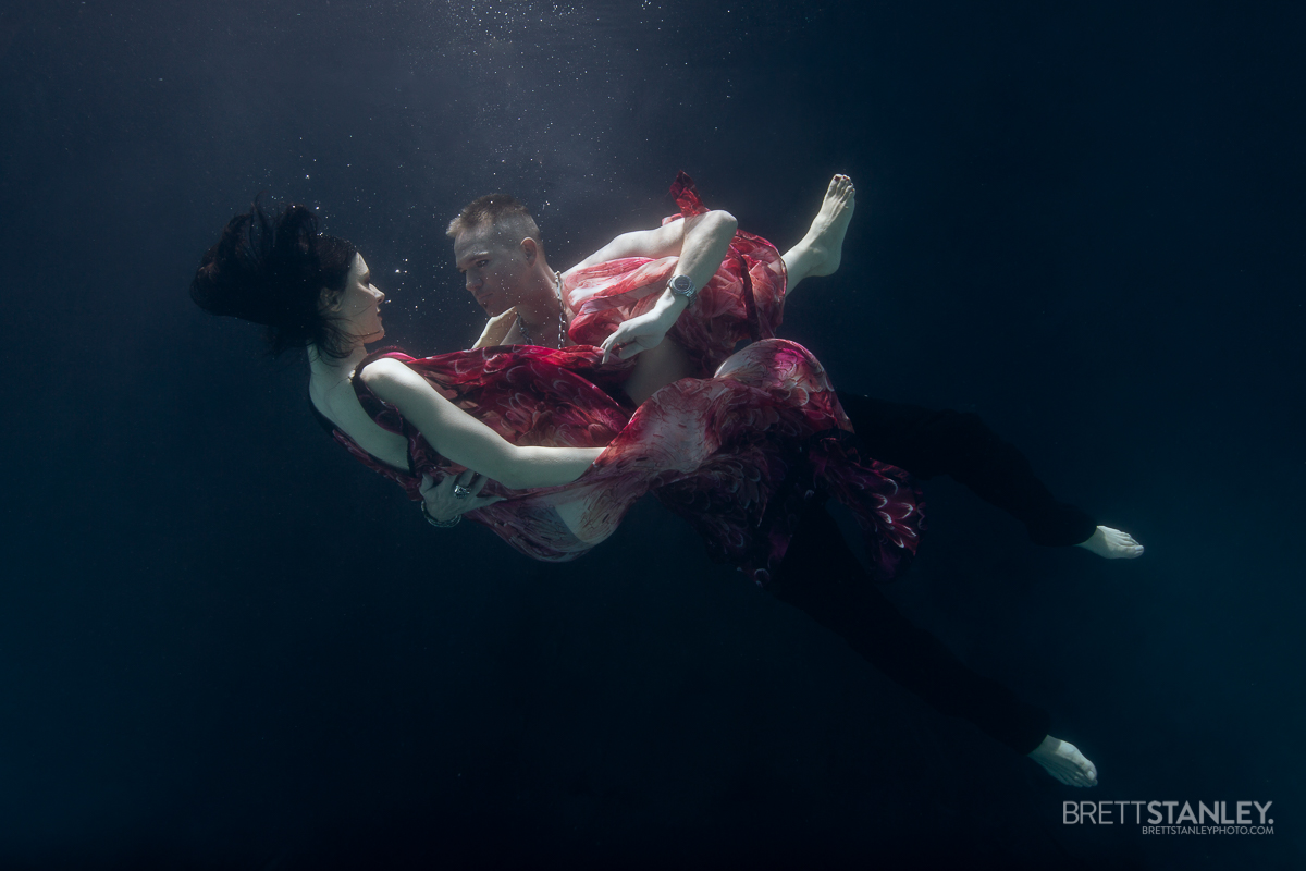 woman and man underwater embracing